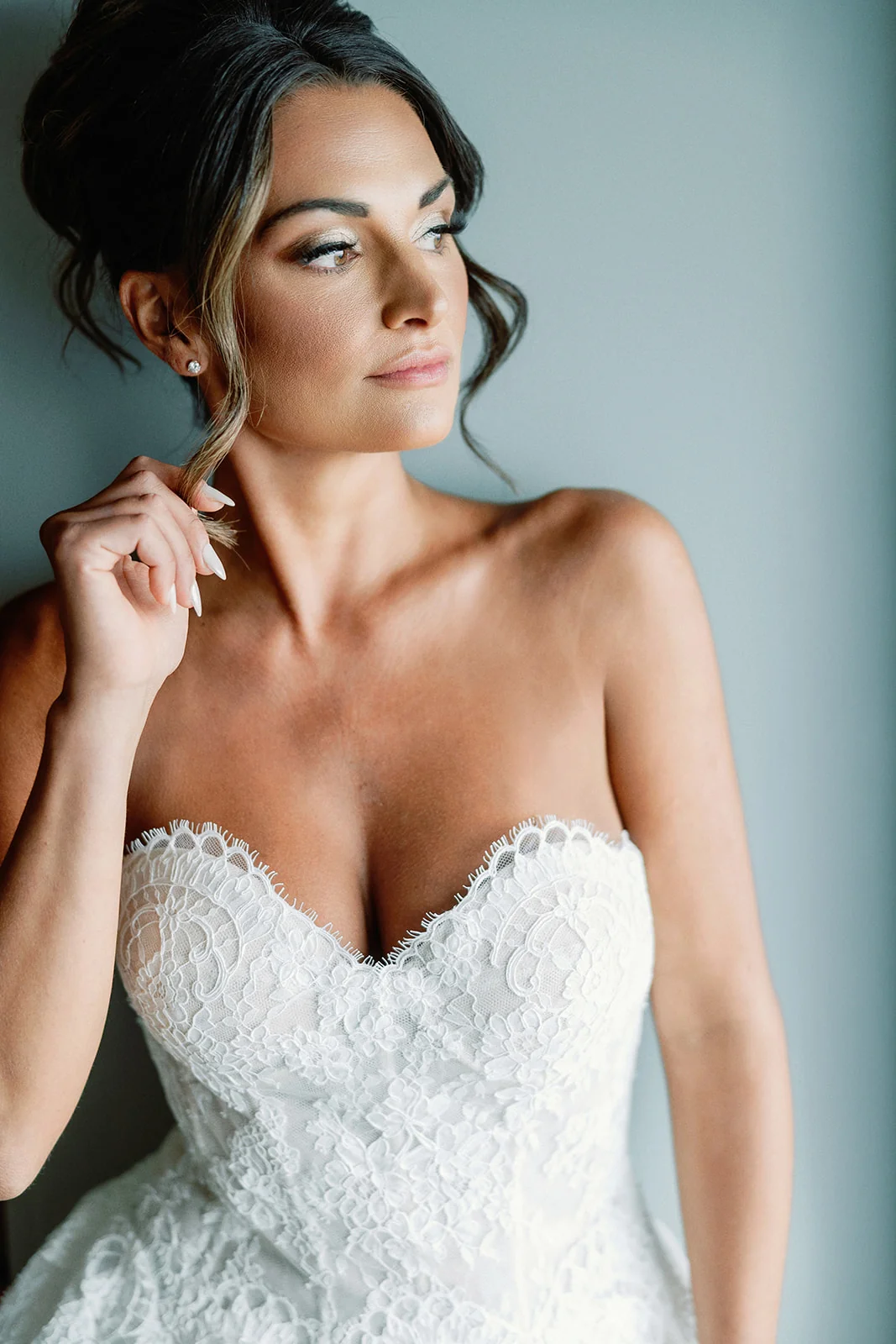 Bride in a lace gown with an elegant updo and softly defined makeup