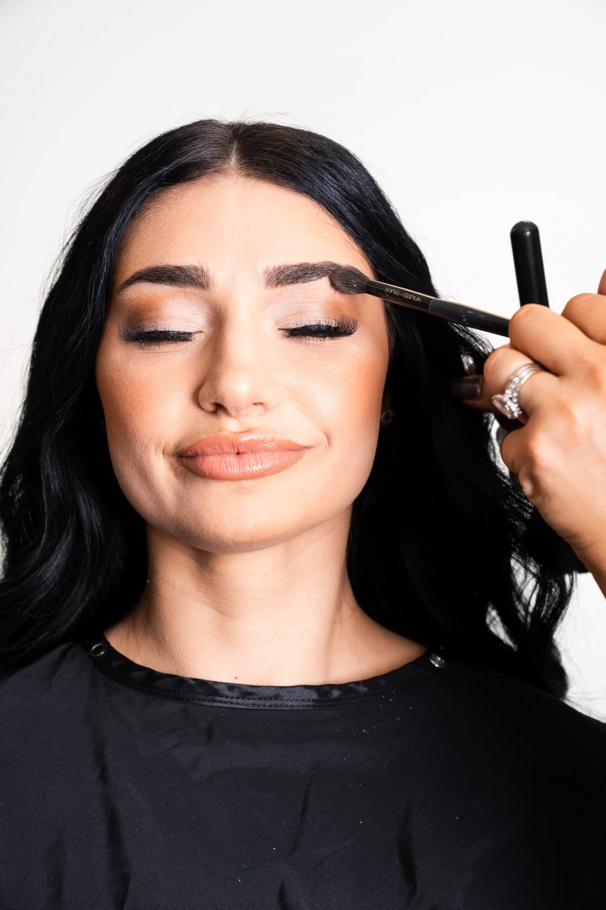 Makeup artist applying finishing details to a client